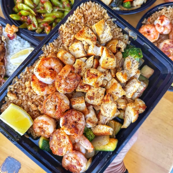 Habachihana Grill's chicken and shrimp hibachi with fried rice and vegetables, garnished with a lime.