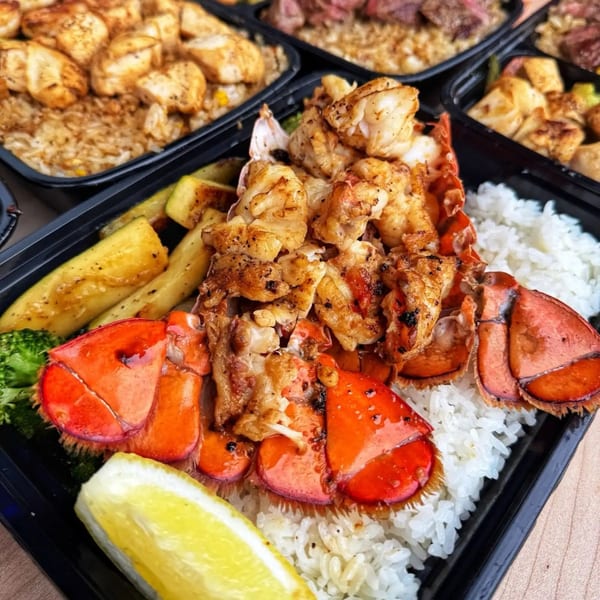 Habachihana Grill's lobster and rice dish with zucchini, broccoli, and a lemon wedge.