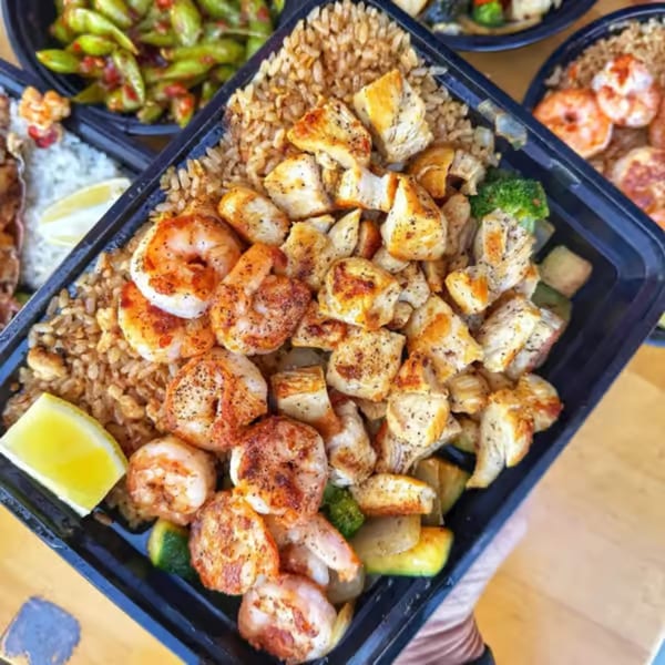 Habachihana Grill's chicken and shrimp hibachi meal with fried rice, vegetables, and a lemon wedge.