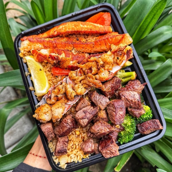 Habachihana Grill's to-go container with salmon, lobster, shrimp, steak, fried rice, and broccoli.