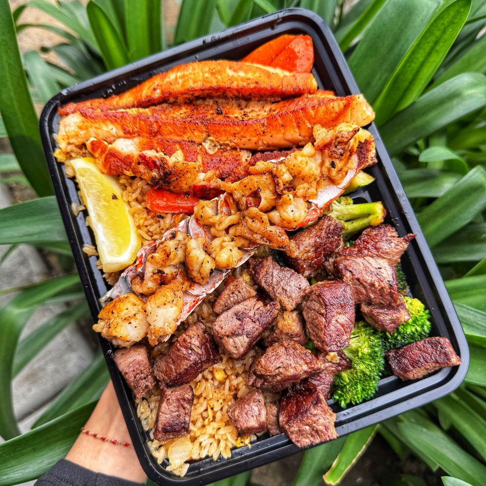 Habachihana Grill's to-go container with salmon, lobster, shrimp, steak, fried rice, and broccoli.