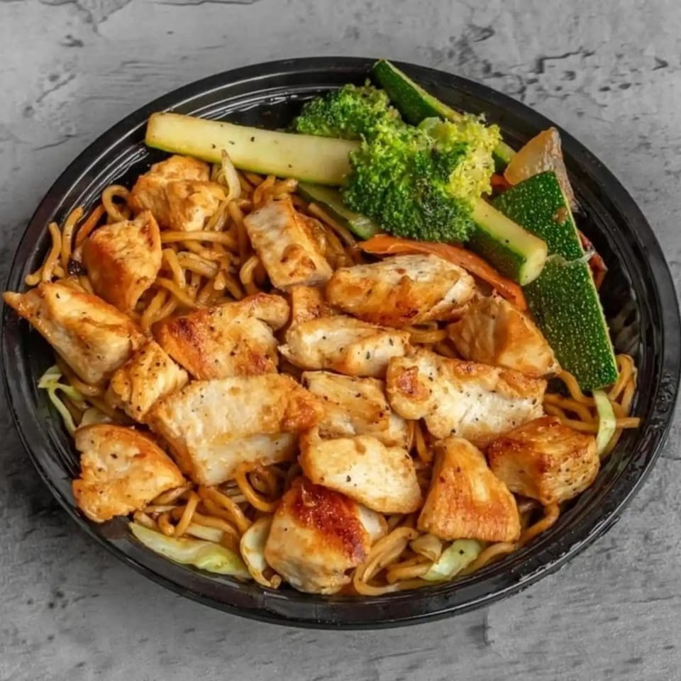 Habachihana Grill's chicken hibachi with noodles, zucchini, broccoli, and carrots in a black bowl.